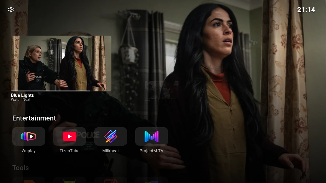 Continue Watching above a compact app row, with programme artwork used as the backdrop